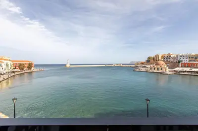 a large body of water with buildings and a lighthouse at Lucia Hotel in Chania Town