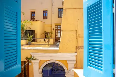 a building with blue shutters in front of it at Lucia Hotel in Chania Town