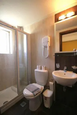 a bathroom with a toilet and a sink and a shower at Hotel Filoxenia in Chania Town