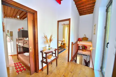 a living room with a stairway and a room with a table at Archontiko Ilias in Kavoúsion