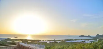 a view of the ocean with the sun in the sky at Archontiko Ilias in Kavoúsion