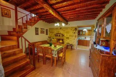 a kitchen and dining room with a table and chairs at Archontiko Ilias in Kavoúsion