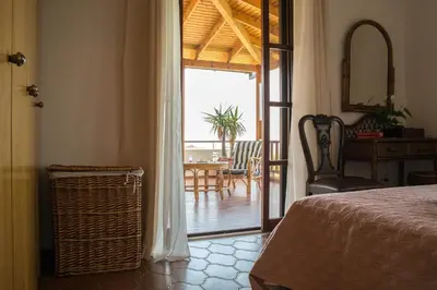 a bedroom with a bed and a door to a patio at Alexandra Villa Stalos in Stalos