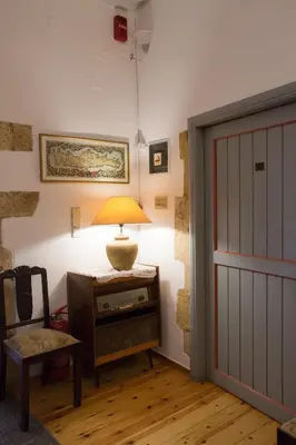 a room with a door and a lamp on a table at Nostos Hotel in Chania Town