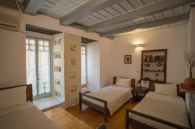 a bedroom with two beds and a window at Nostos Hotel in Chania Town