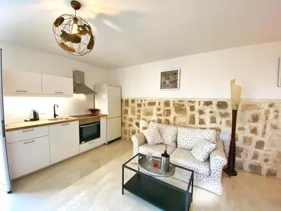 a living room with a couch and a table at MG Cozy Garden View Studio in Korakiaí