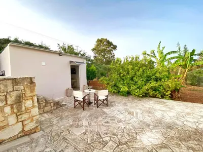 a patio with two chairs and a table at MG Cozy Garden View Studio in Korakiaí