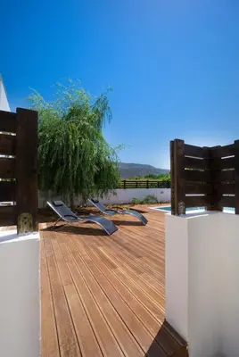 a wooden deck with lounge chairs and a fence at Seametry Villa in Chania Town