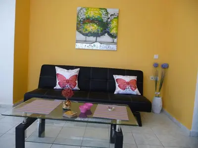 a living room with a black couch and a table at Halepa Studios in Chania Town