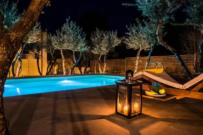 a swimming pool at night with a lighted lantern at Koukounari luxury villa in Chania Town