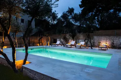 a swimming pool with lounge chairs next to a building at Koukounari luxury villa in Chania Town