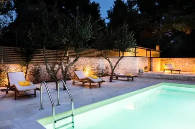 a swimming pool with two chairs and a table at Koukounari luxury villa in Chania Town