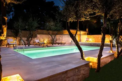 a swimming pool in a backyard at night with trees at Koukounari luxury villa in Chania Town