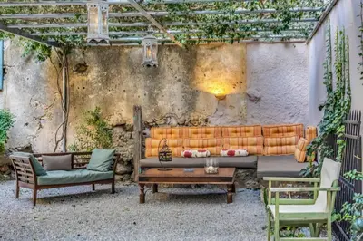 an outdoor patio with a couch and two chairs at Sofia's Lovely Rooms in Khóra Sfakíon