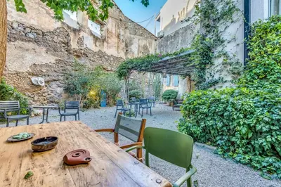 a wooden table and chairs in a courtyard at Sofia's Lovely Rooms in Khóra Sfakíon