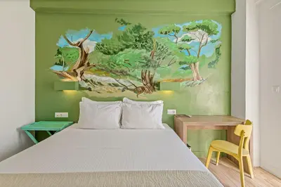 a bedroom with a bed and a painting on the wall at Sofia's Lovely Rooms in Khóra Sfakíon