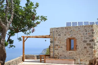 a stone building with a window and a tree at Captain Nikolas in Keramotí