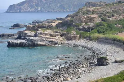 a rocky beach with the ocean and a mountain at Captain Nikolas in Keramotí