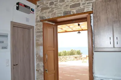 a door to a room with a view of the ocean at Captain Nikolas in Keramotí