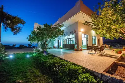 an exterior view of a house with a table and chairs at Panorama in Elafonisi