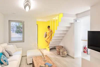 a living room with a white couch and stairs at Aenaon Seaview Villa in Plataniás
