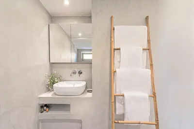 a bathroom with a towel ladder and a sink at Aenaon Seaview Villa in Plataniás