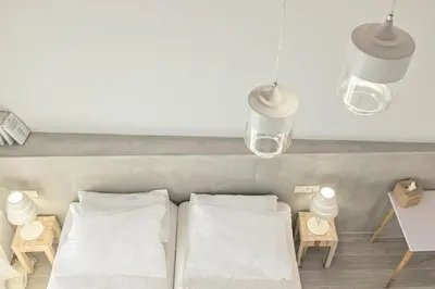 two beds in a room with two lamps and tables at Aenaon Seaview Villa in Plataniás