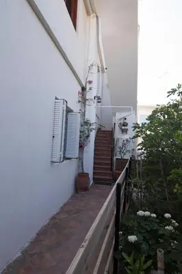 a stairway leading to a white building with two windows at Niki Rooms in Palaiochóra