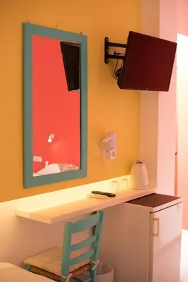 a bathroom with a desk with a mirror and a chair at Niki Rooms in Palaiochóra