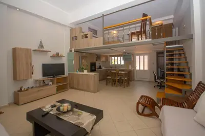 a living room and kitchen with a loft at Maria's house in Kissamos
