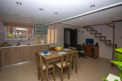 a kitchen with a wooden table and a dining room at Maria's house in Kissamos