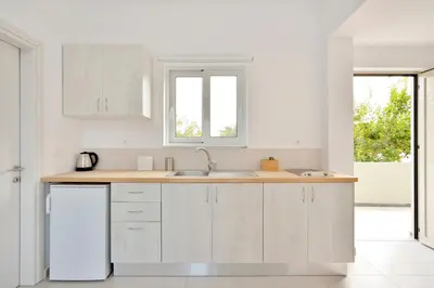 a kitchen with white cabinets and a sink at Casa Manolesos in Chorafakia