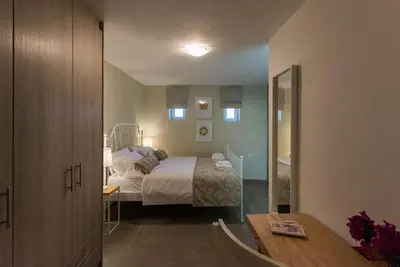 a bedroom with a bed and a room with a table at Margiani House in Kaláthenai