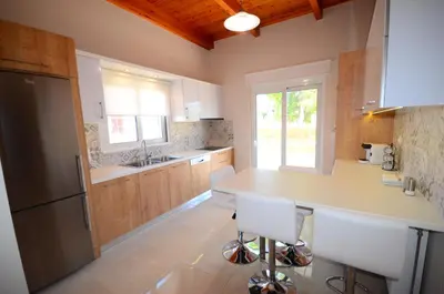 a kitchen with a counter and a sink and a refrigerator at Villa Despina in Kisamos in Kissamos