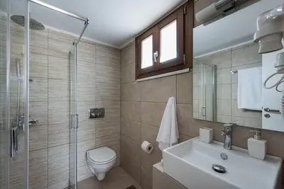 a bathroom with a toilet and a sink and a shower at Villa Filoxenia 1937 in Gerani Chanion