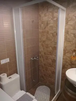a bathroom with a shower and a toilet and a sink at Agora Apartments Ground Floor in Kissamos