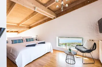 a bedroom with a bed and a window and a chair at Yellow Dream Villas in Chorafakia