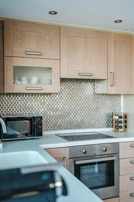a kitchen with wooden cabinets and a microwave at Yellow Dream Villas in Chorafakia