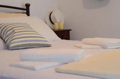 a bed with white sheets and a pillow on it at Christina Apartment in Kissamos