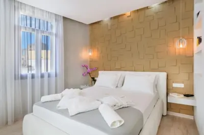 a bedroom with a white bed with towels on it at Diamond Luxury Suites in Chania Town