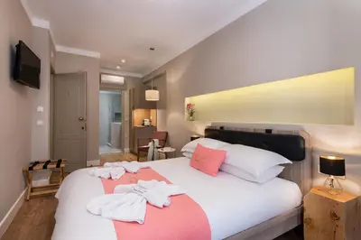 a bedroom with a large bed with towels on it at Viaggio Elegant Rooms in Chania Town