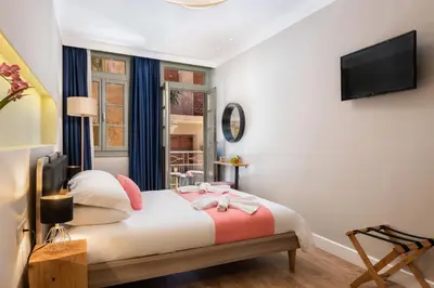 a bedroom with a bed and a tv on a wall at Viaggio Elegant Rooms in Chania Town