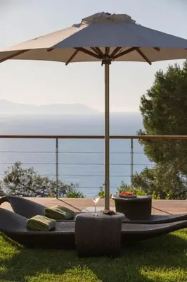 a table with an umbrella and some chairs and a table with at VILLA TERRA CRETA Luxury Retreat and Spa in Chania Town