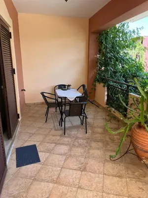 a patio with a table and chairs and a plant at Rosmarino in Kissamos