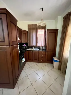 a kitchen with wooden cabinets and a tile floor at Rosmarino in Kissamos