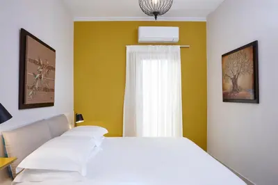 a bedroom with a white bed and a window at La Vita Classica in Chania Town