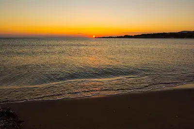 a sunset over the ocean with a beach at Villas Paleochora in Palaiochóra