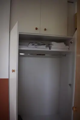 a closet with white cabinets and white towels at Studios Staring at the Sunset in Chania Town