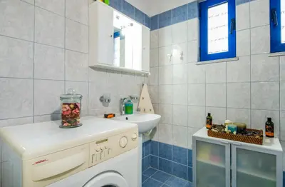 a bathroom with a washing machine and a sink at Oasea in Tavronitis