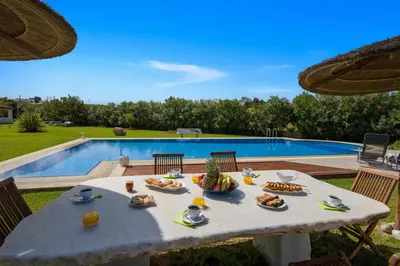 a table with food on it next to a pool at Oasea in Tavronitis